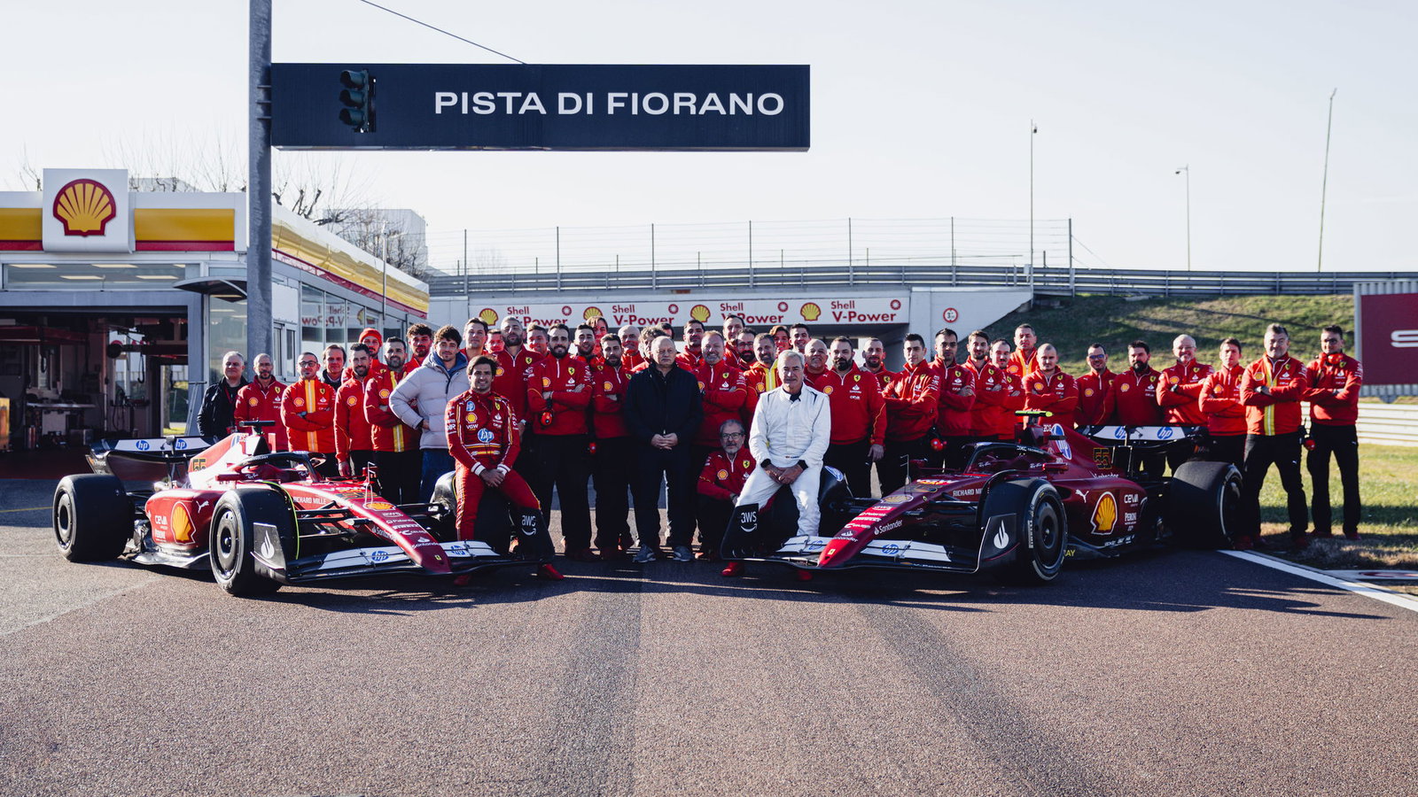 Carlos Sainz Jr. and Sr. with Ferrari F1 cars and team